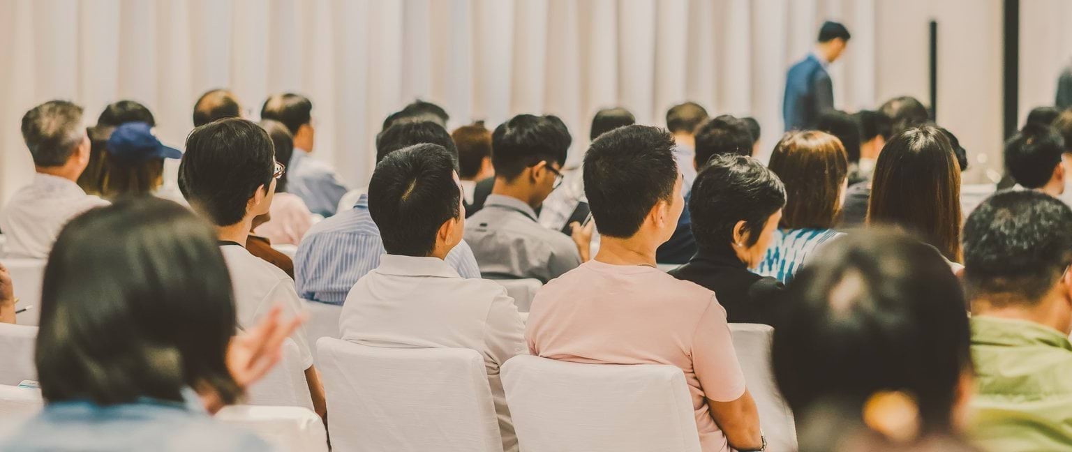 Chinese Community Hall Hire program web banner People seated in a row of seats inside a community hall.