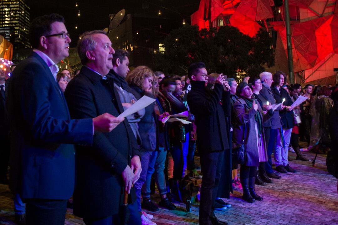 Premier Andrews, Minister for Equality Martin Foley and the crowd sing at the Orlando vigil at Federation Square