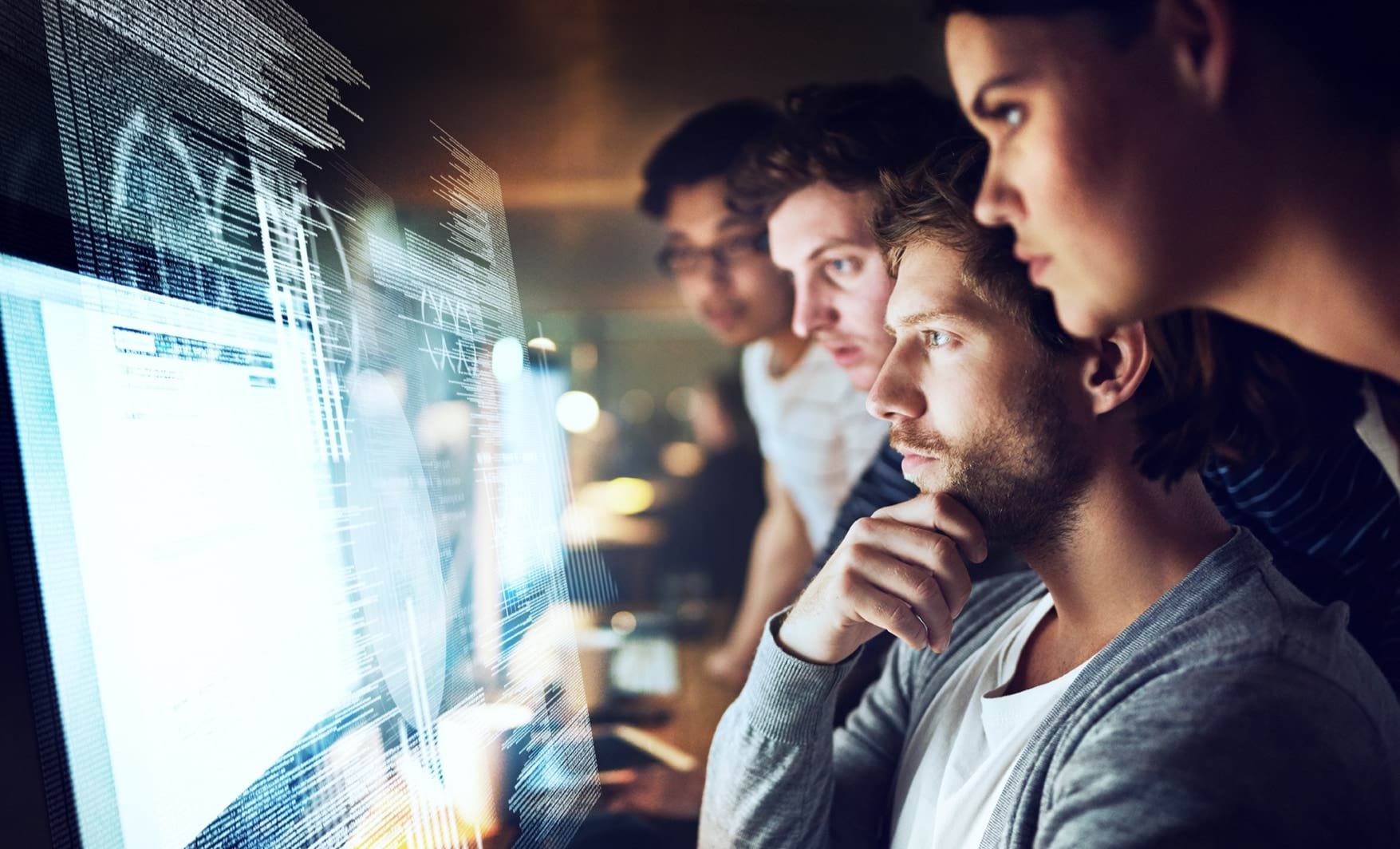 Group of 4 people in front of computer screen