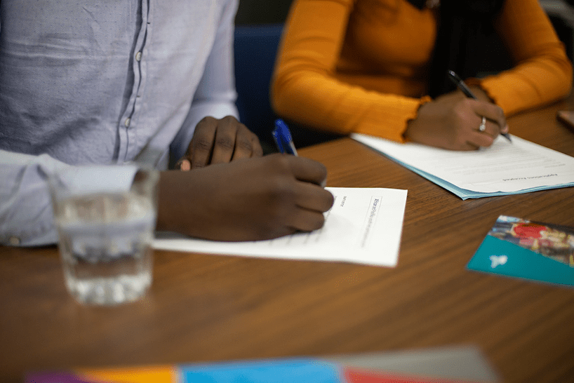 Two young people of African background writing at a desk