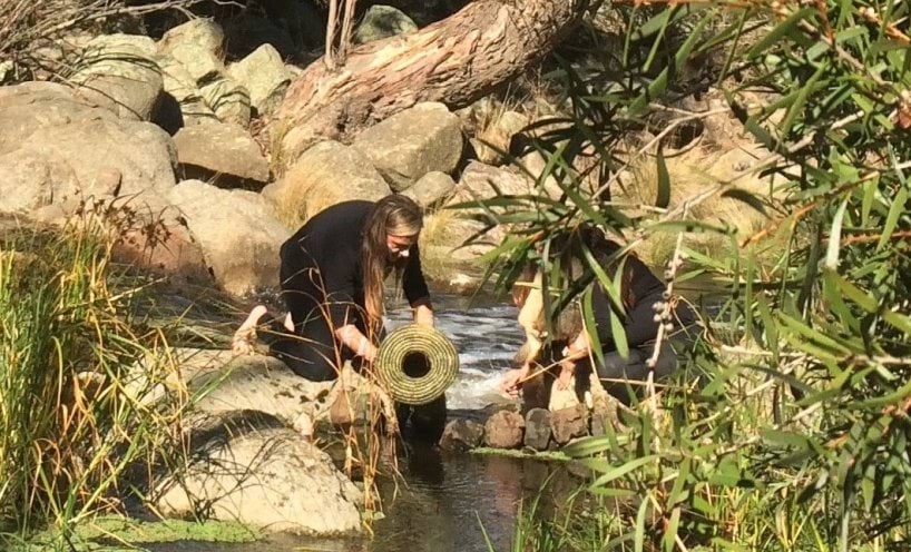 Tammy Gilson kneeling at  river