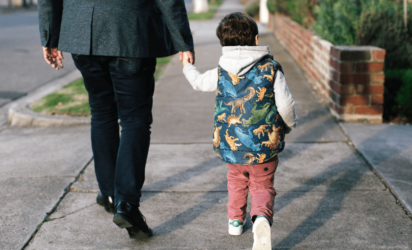 Man and child holding hands and walking 