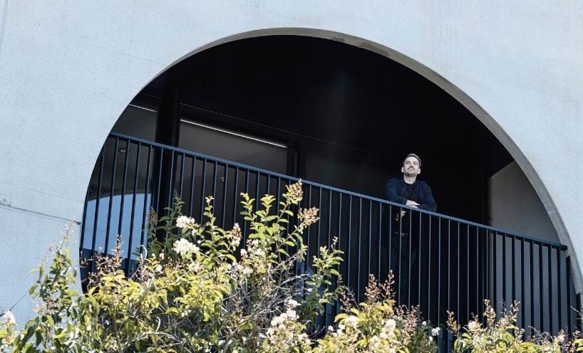 Man looking out from arched balcony