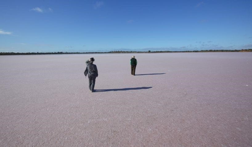 Two people walking across Pink Lakes in Murray-Sunset National Park