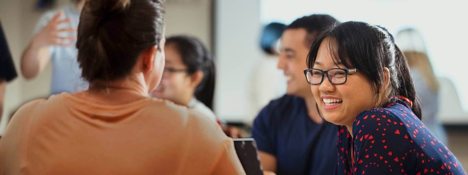 People sitting around a table talking and smiling