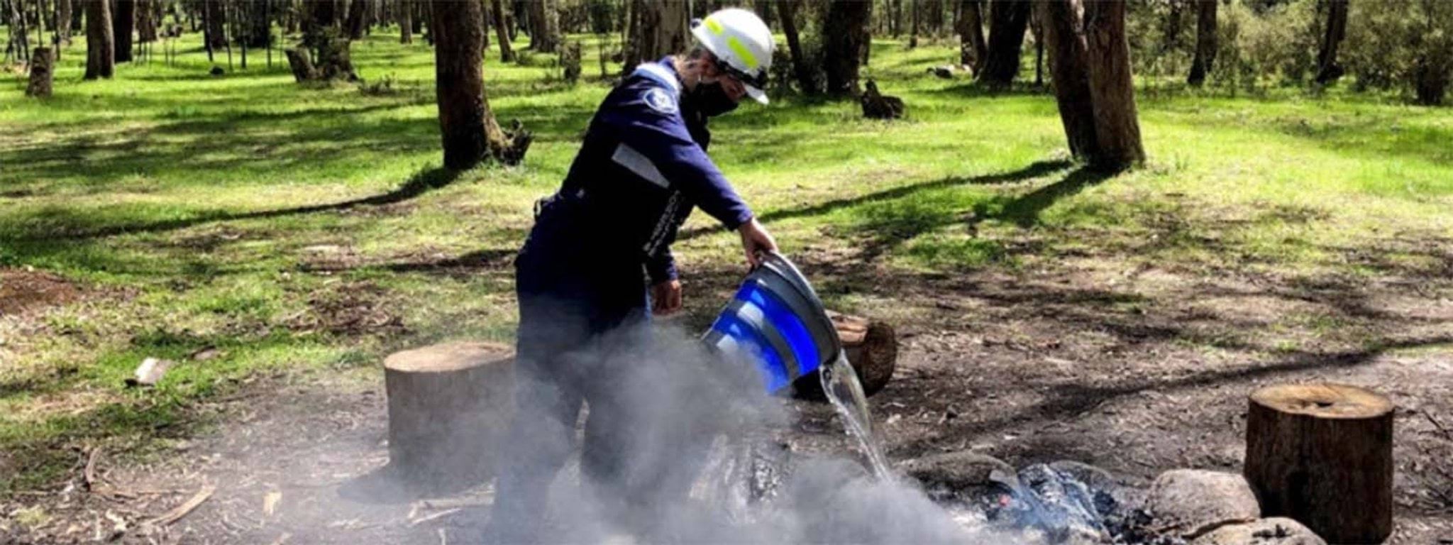 Image of regulatory officer extinguishing an illegal campfire Image of regulatory officer extinguishing an illegal campfire