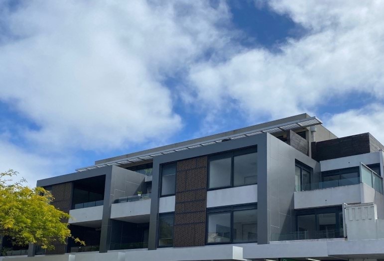 An apartment building with a cloudy sky in the background 