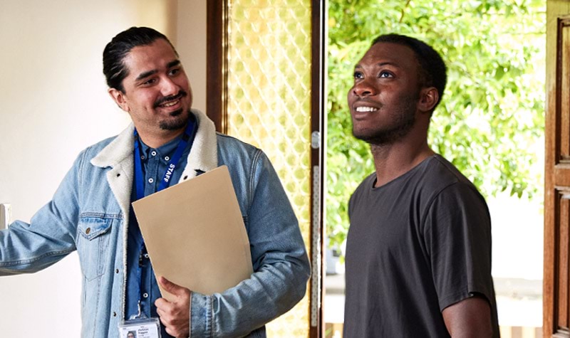 A man being shown around his new home by a Housing worker