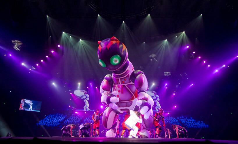 Giant robot cat puppet on the performance stage, surrounded by dancers