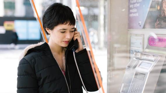 Woman speak on public telephone