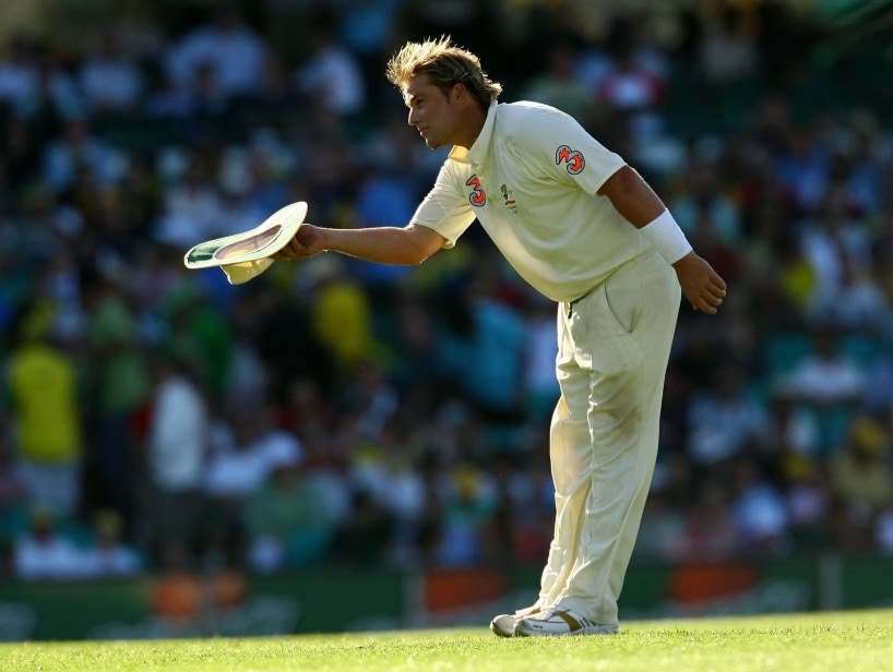 Mr Shane Warne tipping his hat on the cricket field.