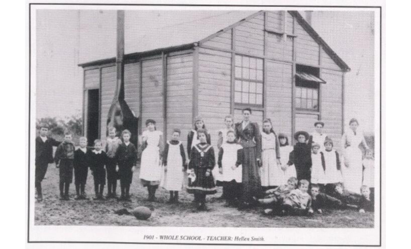 Teacher and children outside Dartmoor State School timber building in 1901.