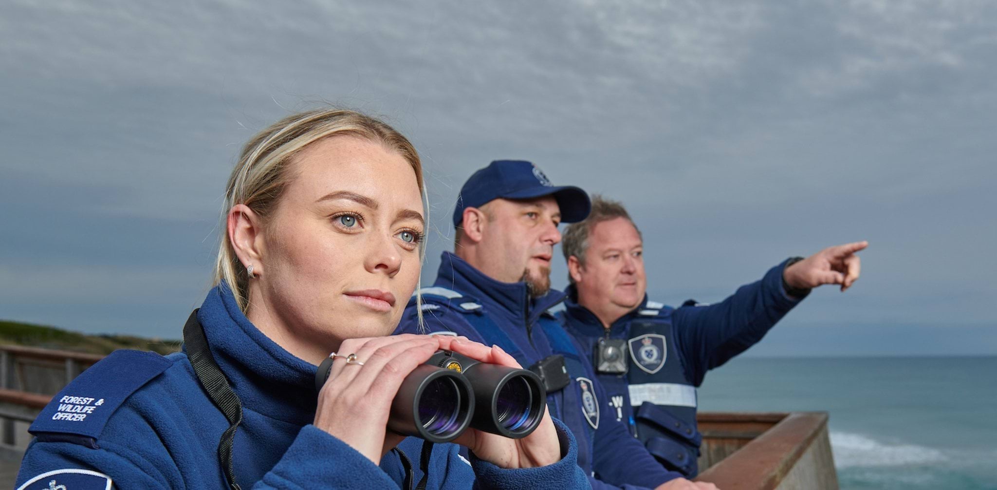Image of forest and wildlife officers overlooking the ocean Image of forest and wildlife officers overlooking the ocean