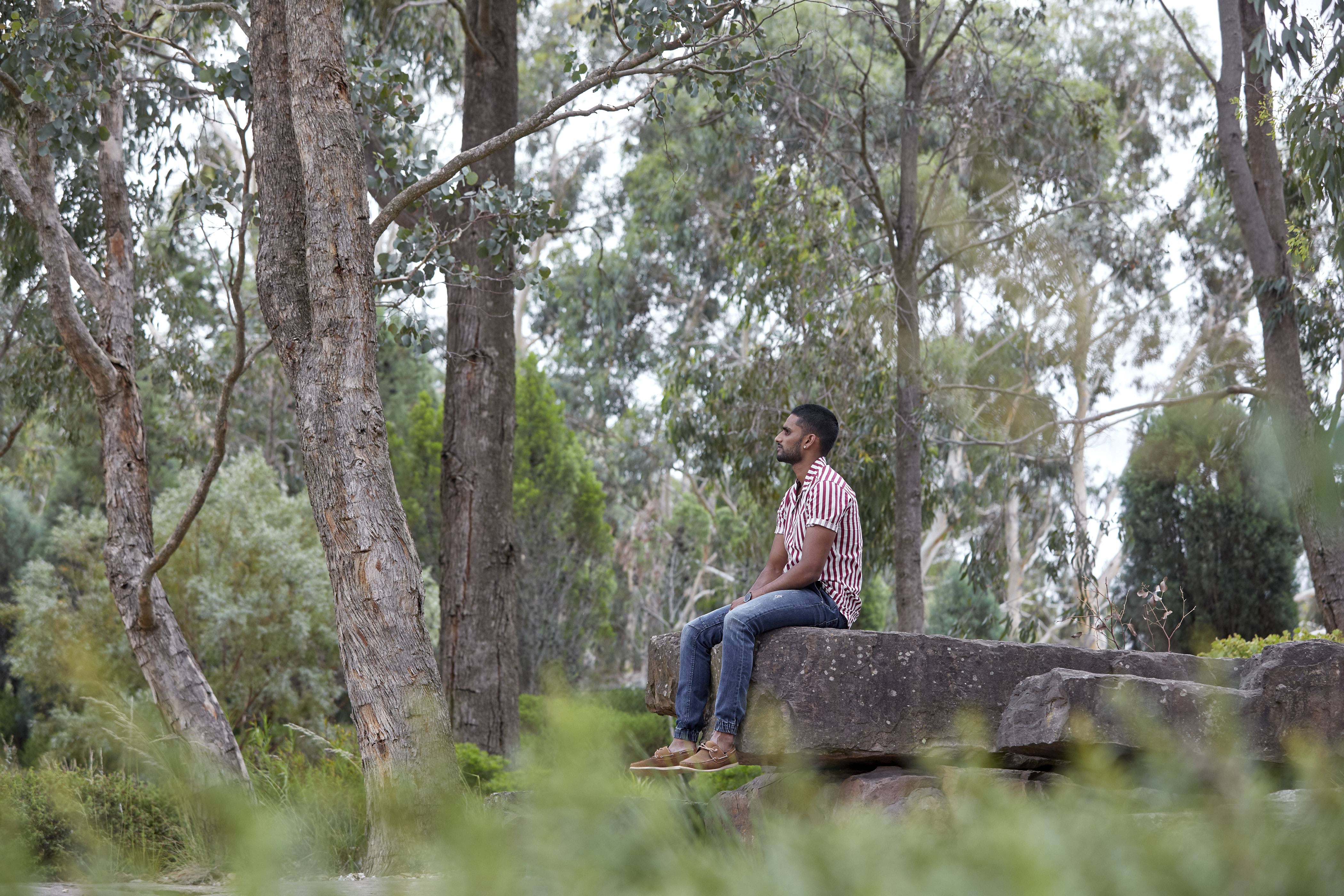 Person sitting on a rock at Cranbourne Gardens