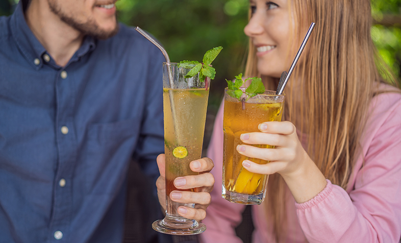 a couple toasting cocktails with resusable straws 