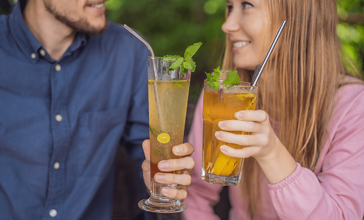 a couple toasting cocktails with resusable straws