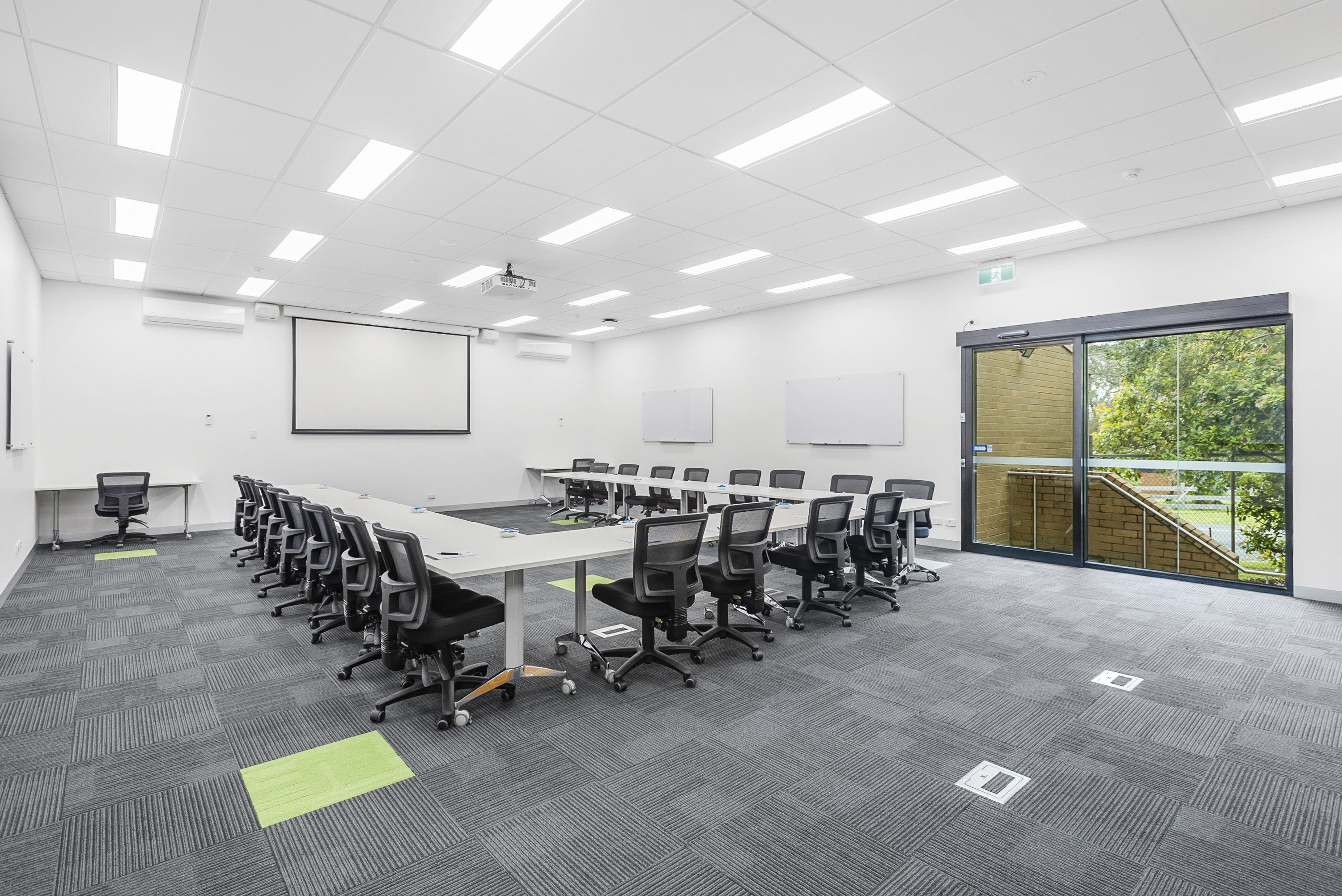 Image shows a meeting room at the VEMI Conference Centre with tables set in a U shape and chairs surrounding the tables.