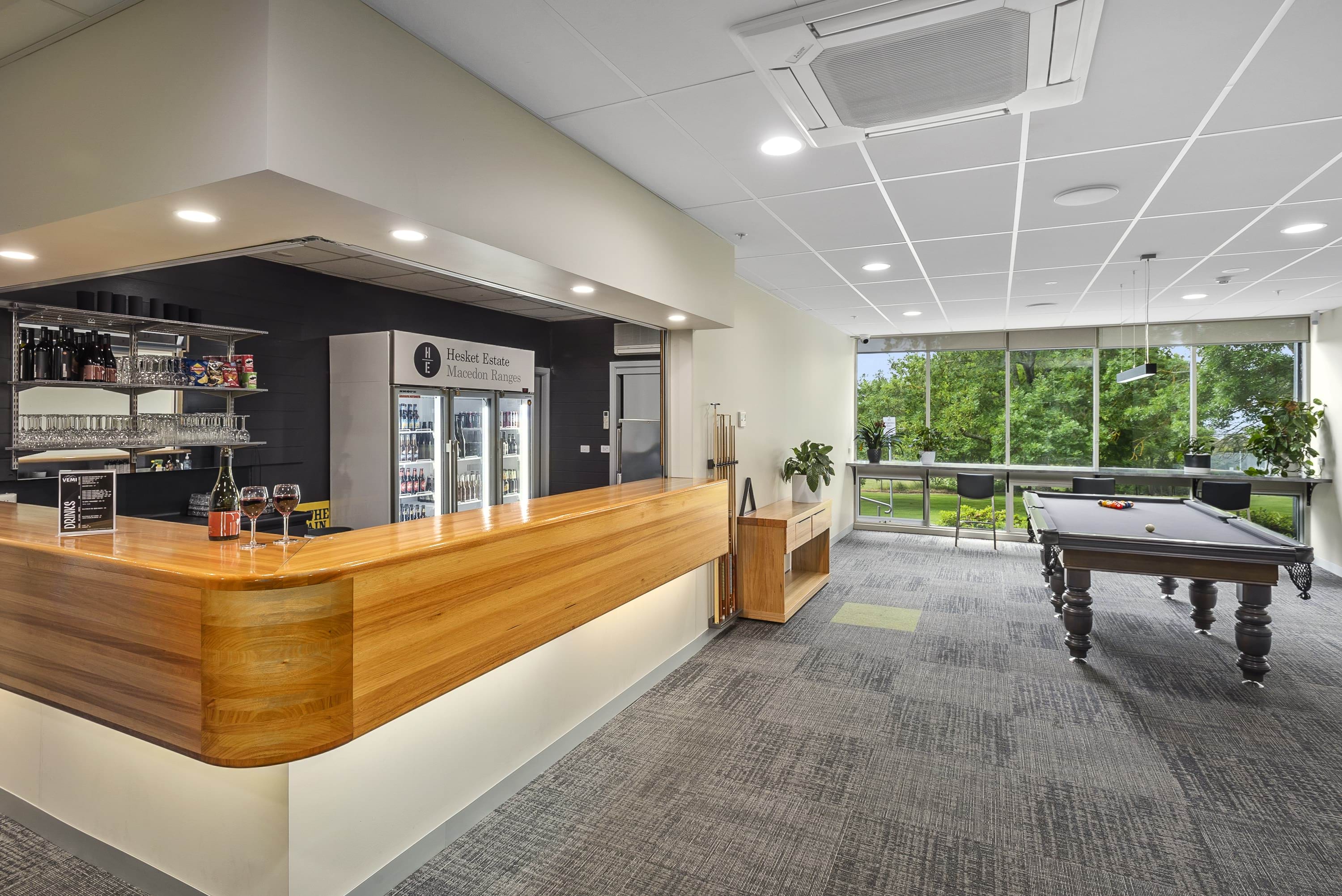 Image shows the VEMI bar are and pool table with a view of outside.