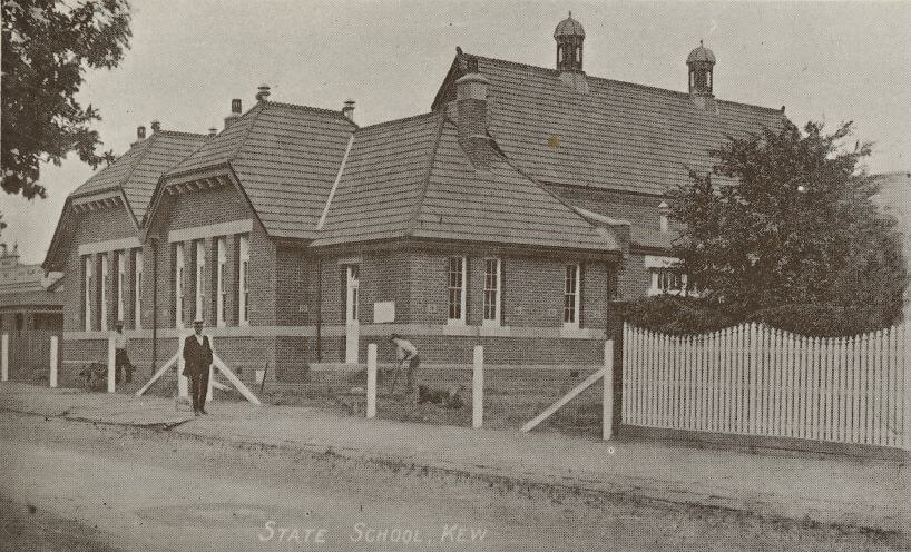 Black and white photograph of the Kew school building with workers in the garden in front of the school 