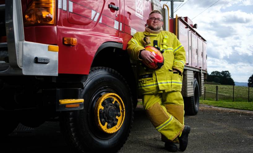 Russell Wright in Country Fire Authority emergency gear leaning against a red CFA truck