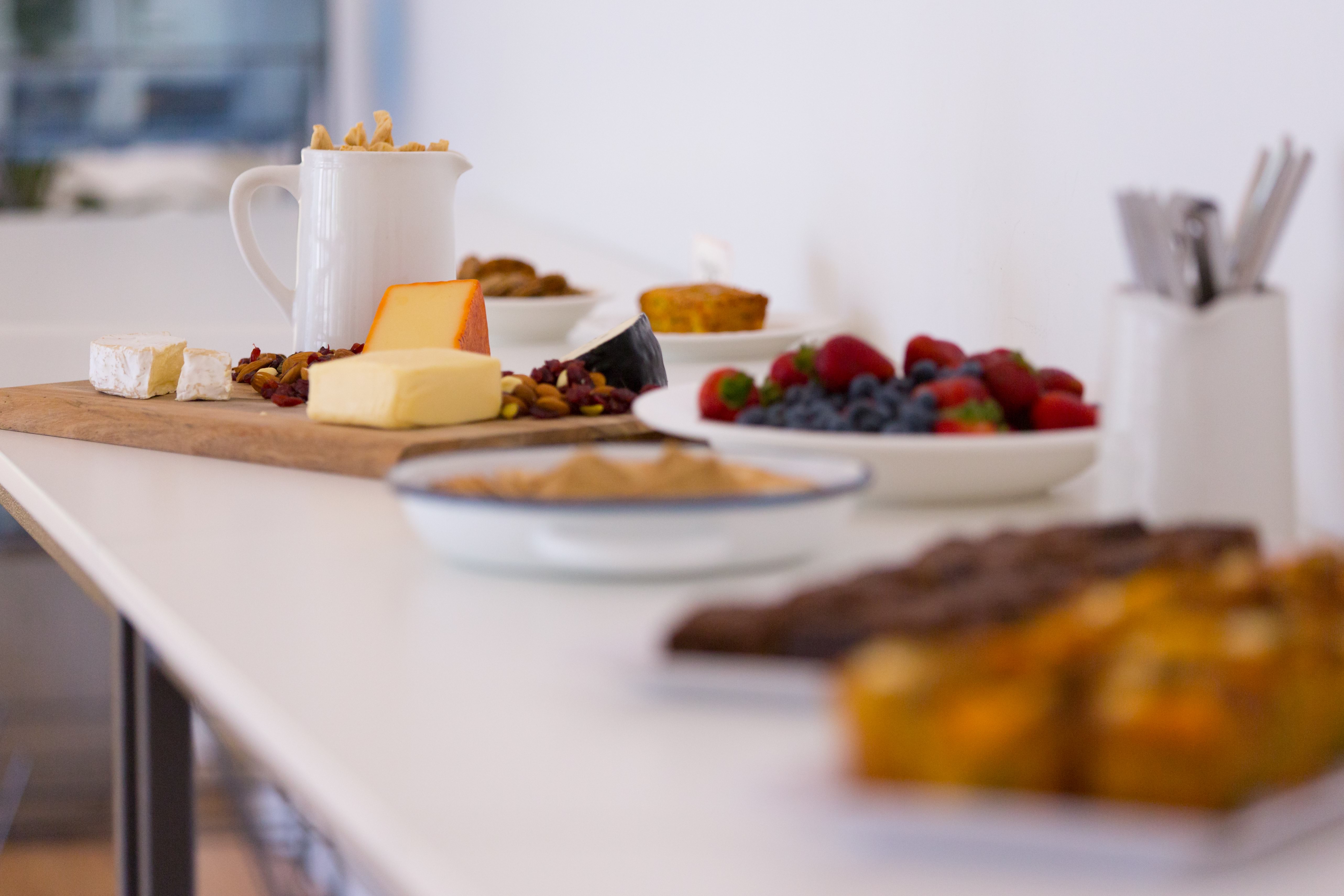 Image shows berries in a bowl and a cheese board