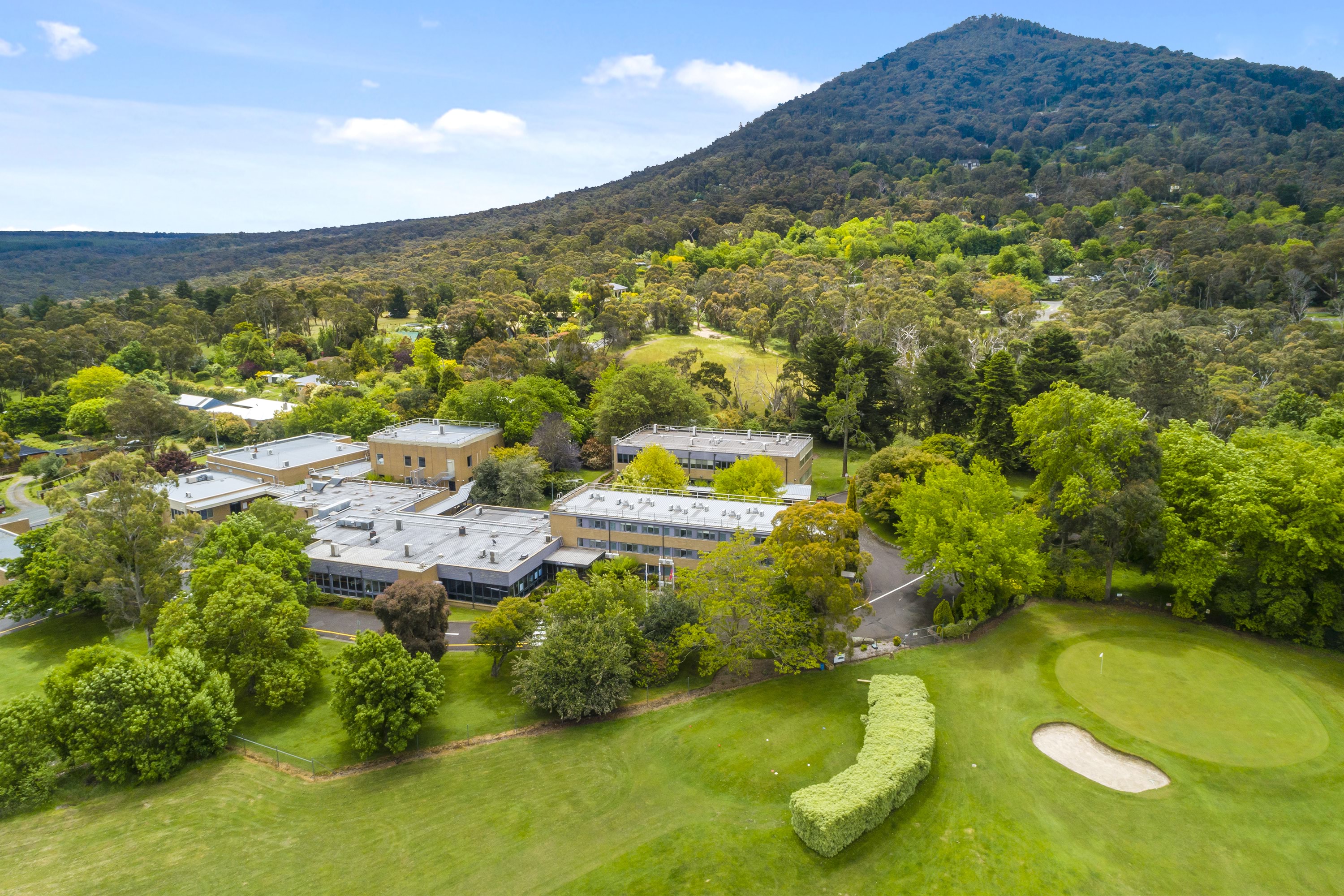 Image shows a birds eye view of the VEMI Conference Centre with Mount Macedon ranges behind