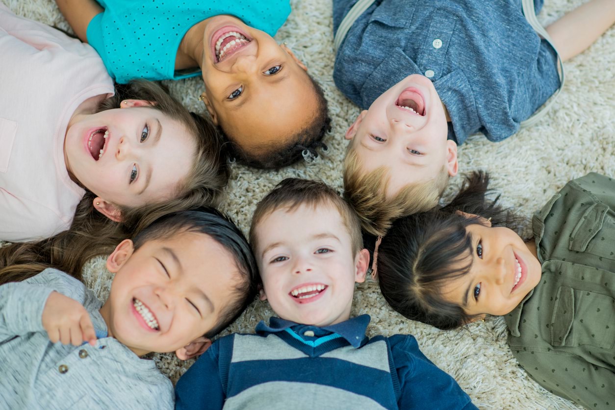 Group of children lying on floor smiling