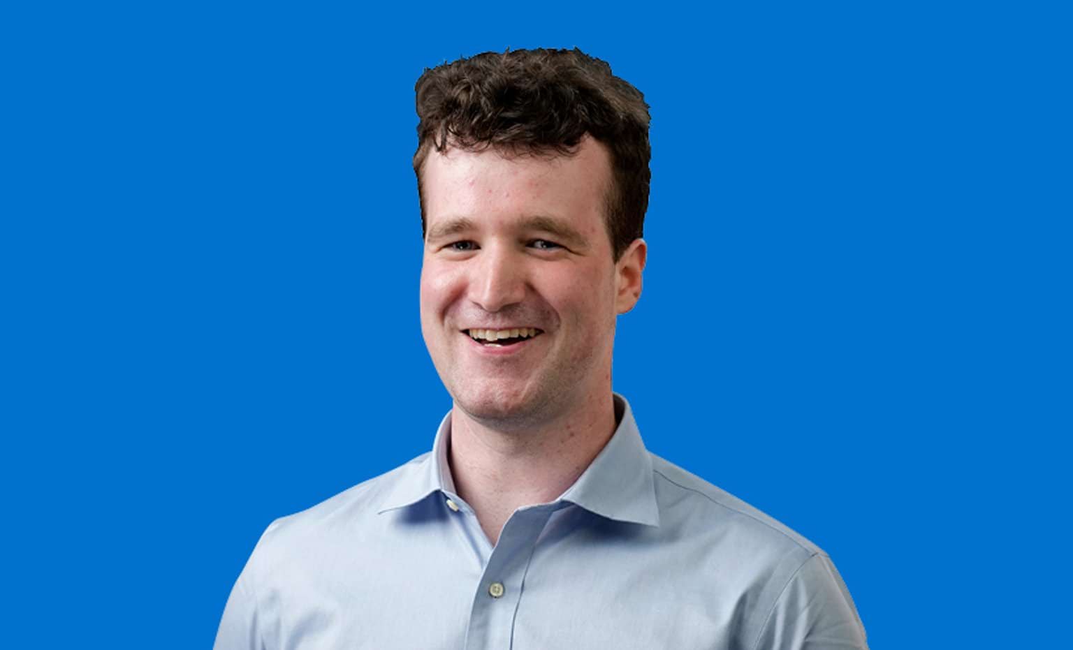 Image of male graduate with blue background behind him