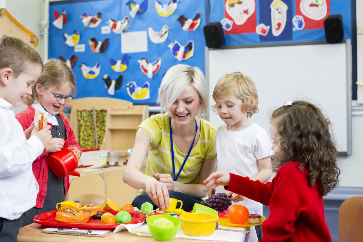 Children with their teacher playing at kinder