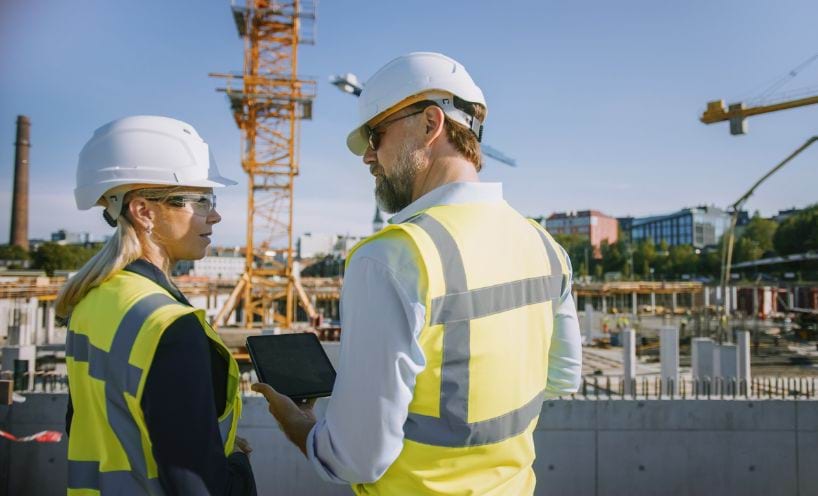 Two people in high-vis overlooking a construction site