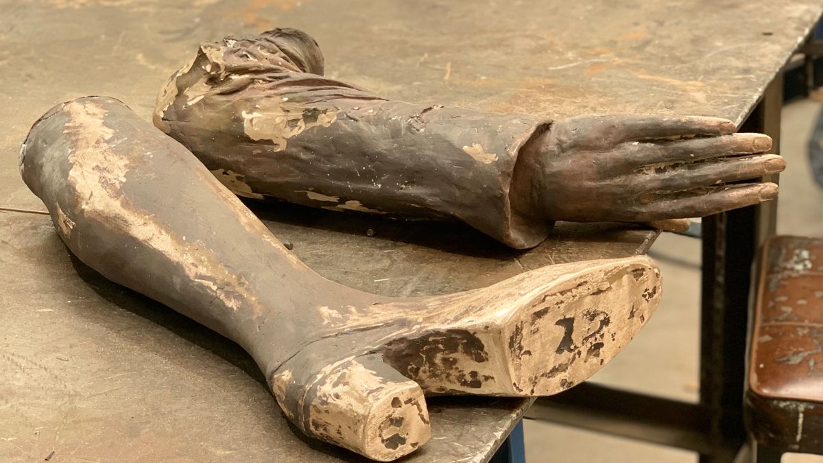 A leg and forearm lie on a bench in the foundry after being cast from their moulds.