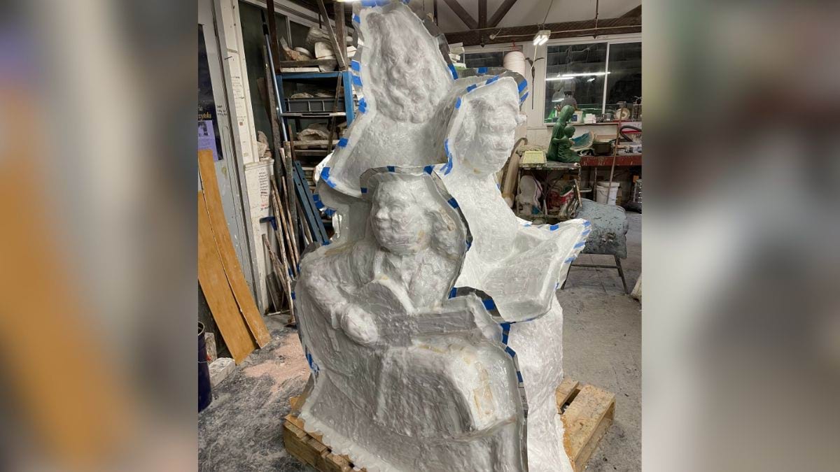 The sculpture is completely covered in plaster to create the casting mould.