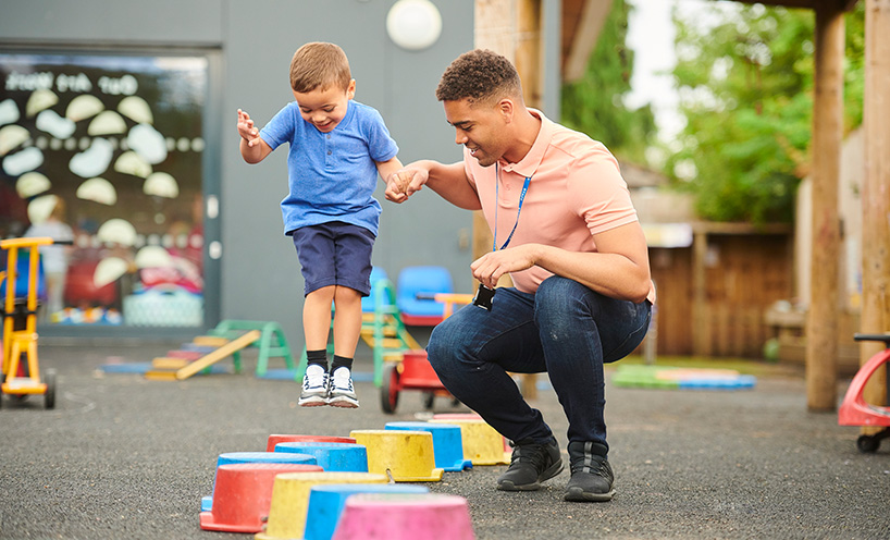 A teacher playing with a kid in a kindergarten.