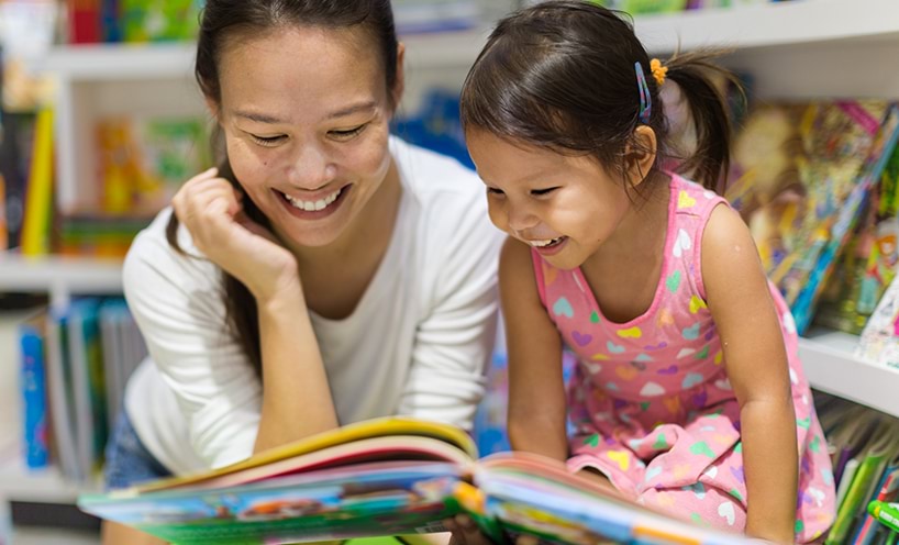 A mother is reading a book with her daughter