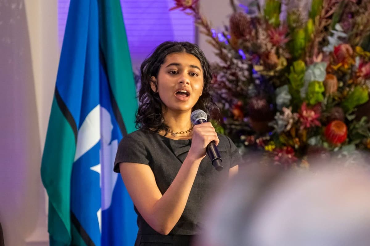 A young person sings into a microphone.