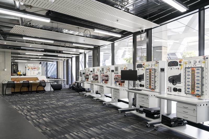 Kangan Institute’s Automotive Centre of Excellence at Docklands electrical vehicle lab showing a classroom with desks and electrical vehicle training screens for learners