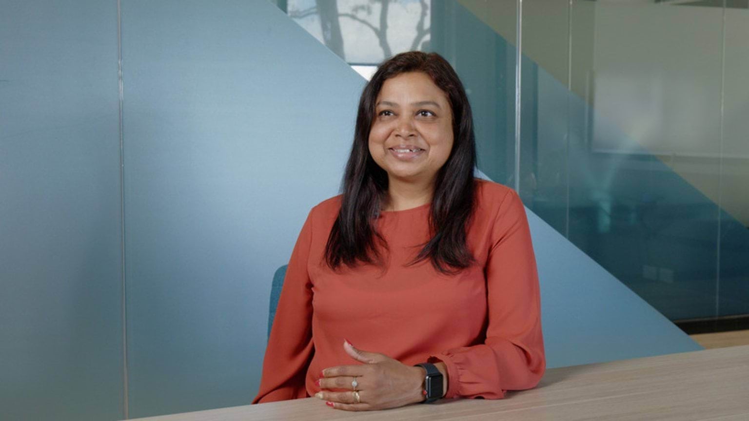 Veena student satisfaction survey sitting at desk talking about her learning experience