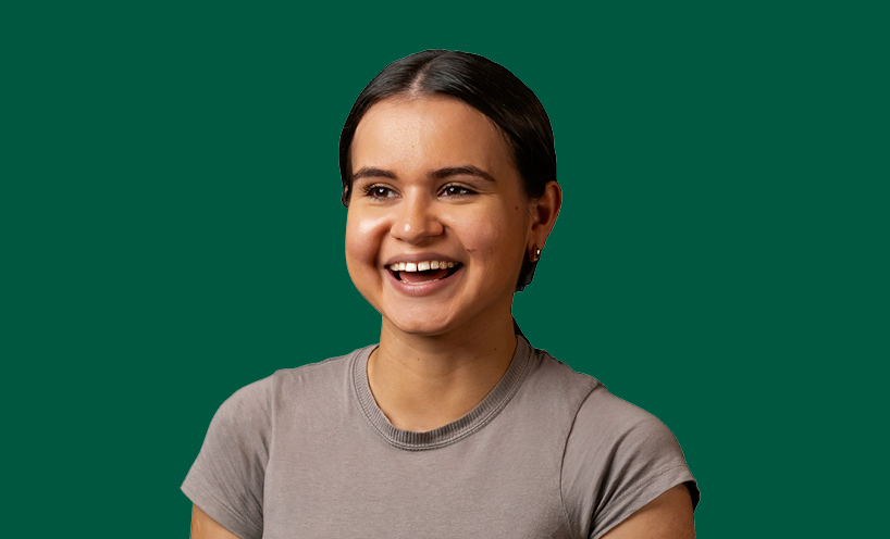 A smiling graduate on a green background