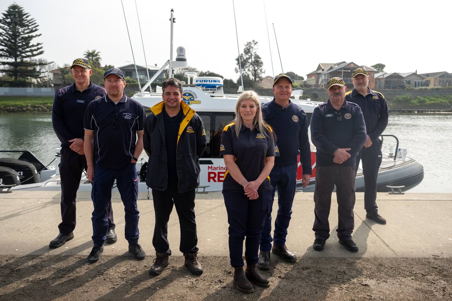 Image shows 7 smiling crew members lined up for a photo in front of a MSAR boat.