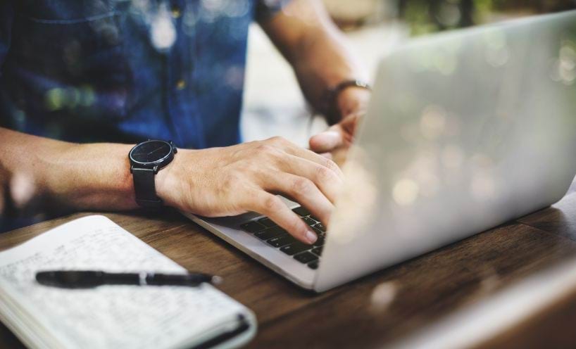 A person using a laptop on a desk