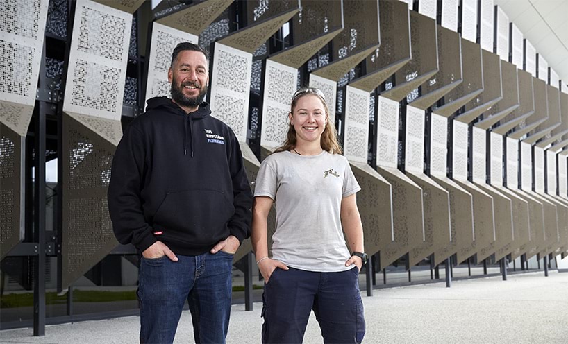 Victorian Skills Plan Gippsland TAFE man and woman in front of institution building smiling at camera with hands in pocket