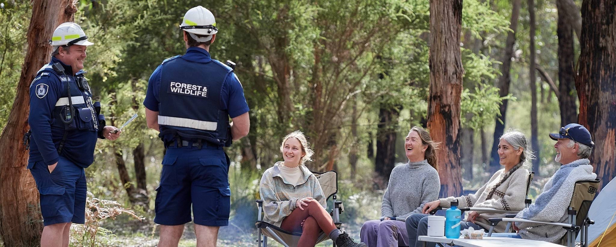 Photo of two Forest and Wildlife officers chatting with four campers Photo of two Forest and Wildlife officers chatting with four campers