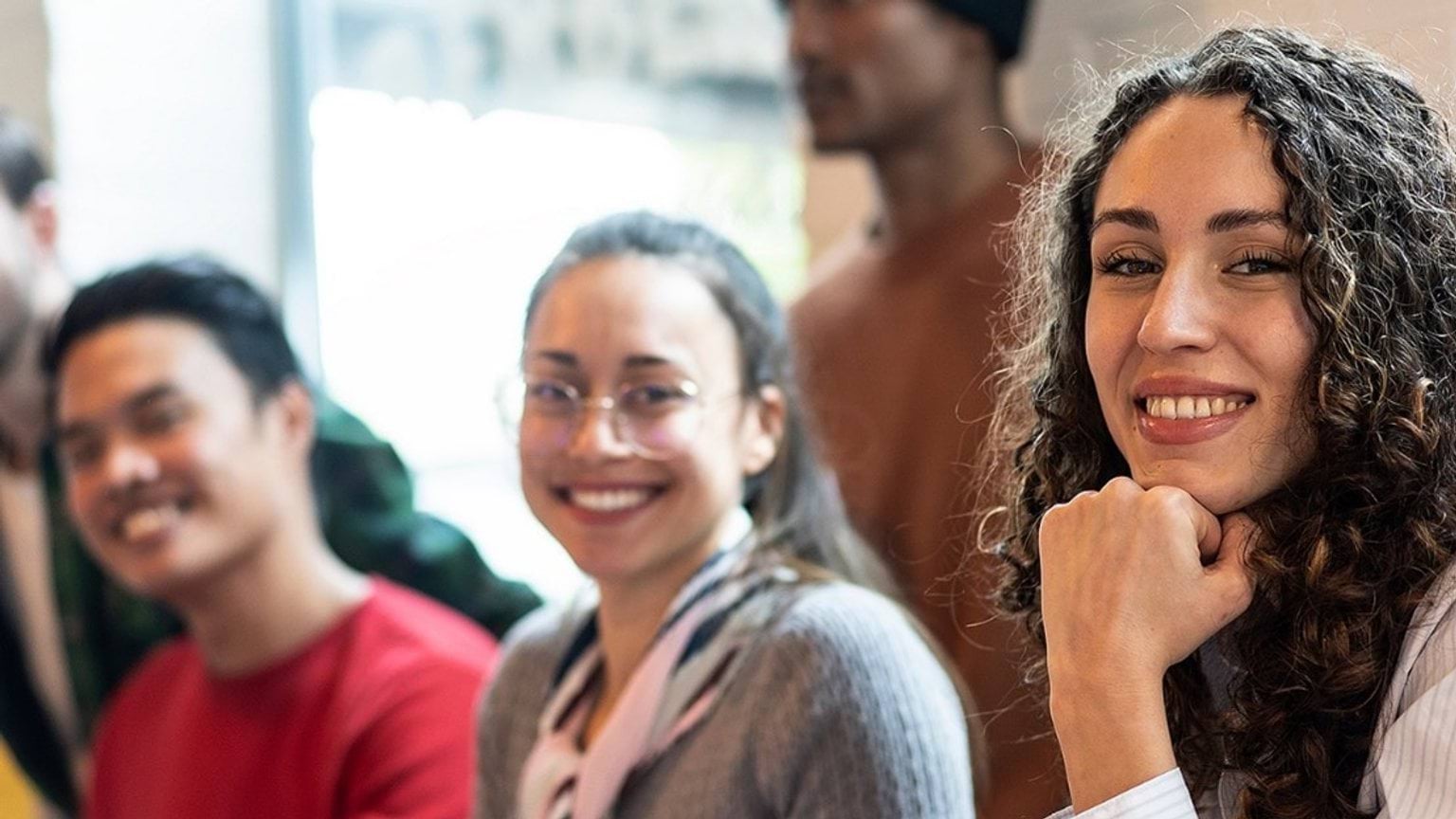Happy students in a classroom 2 female and 1 male student smiling