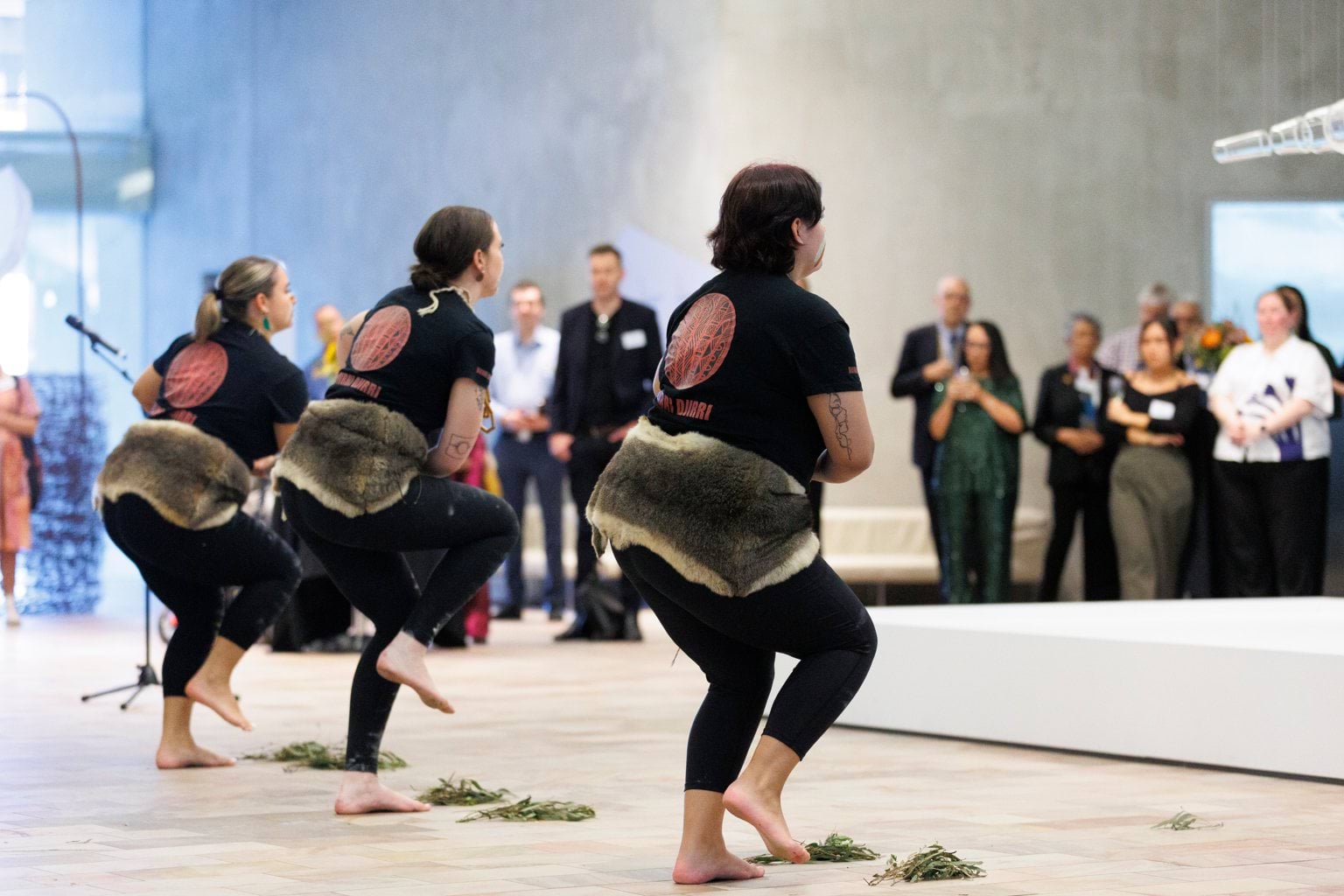 Three First Nations dancers in traditional dress