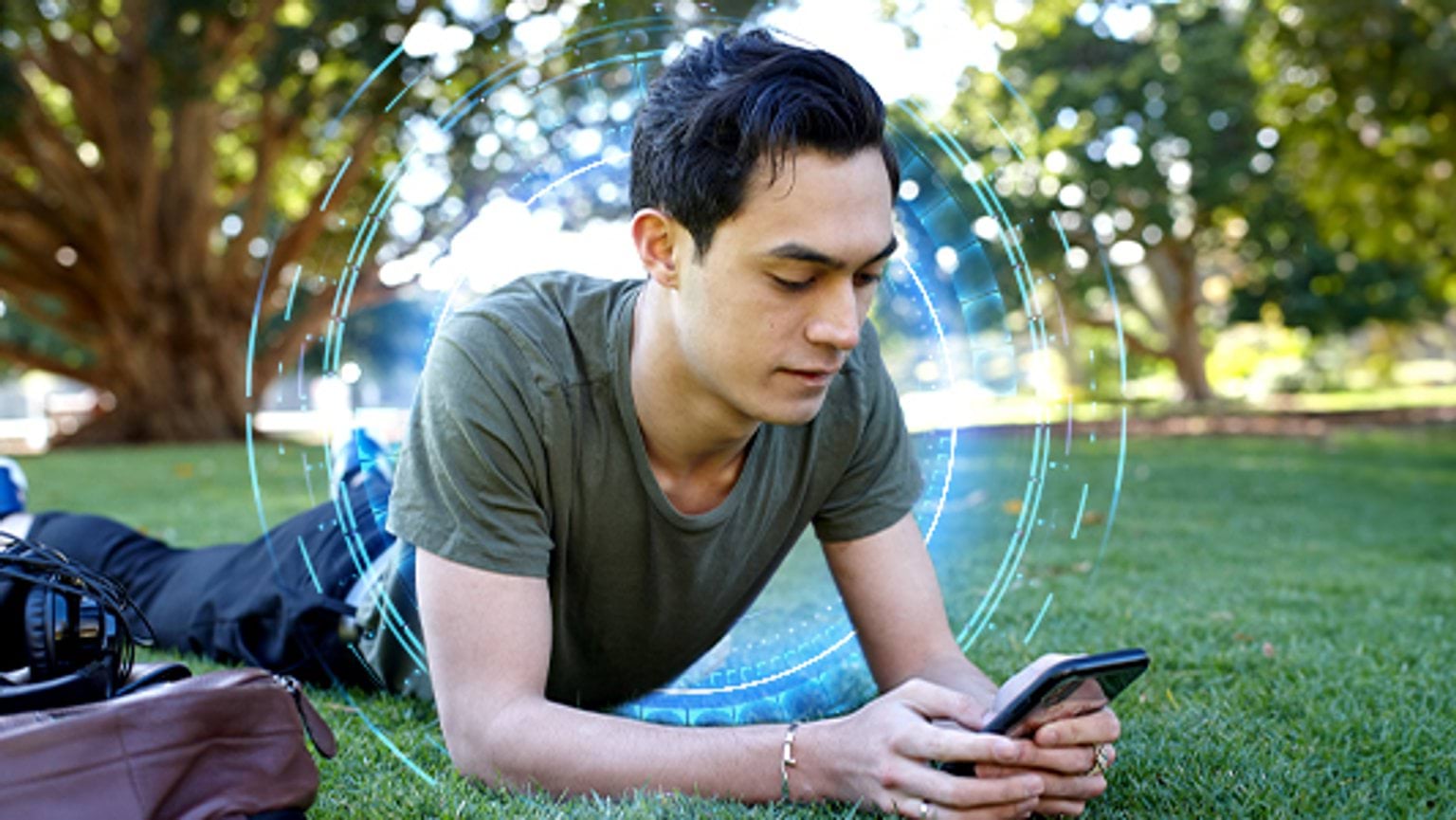 Cyber safety tips Man lying on grass on his phone learning about cyber safety tips