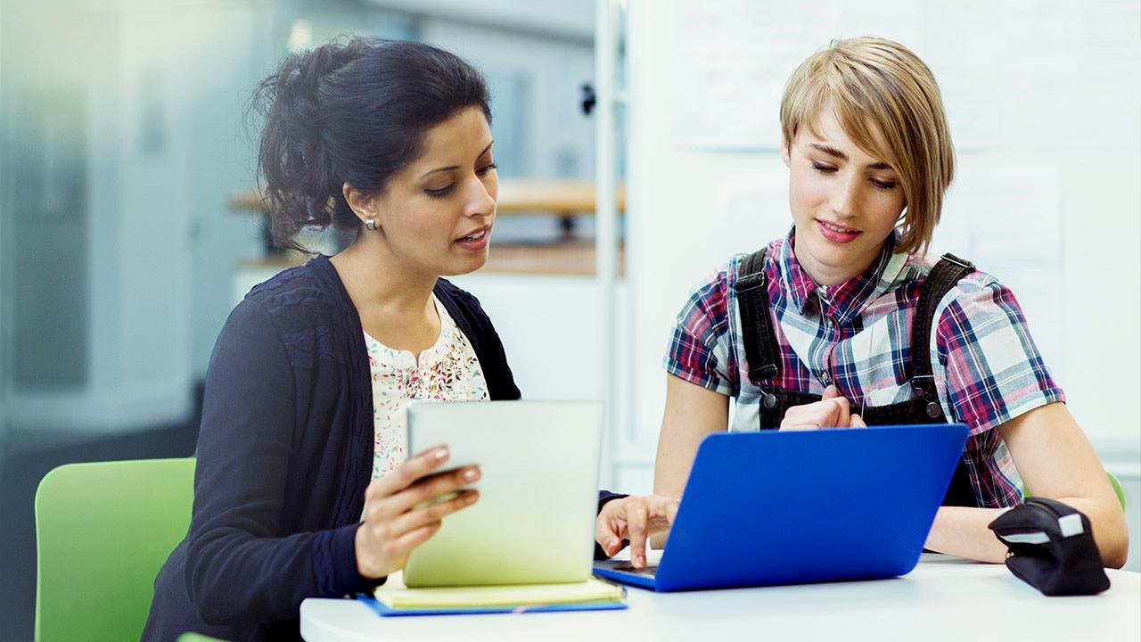 Two people looking into laptop together