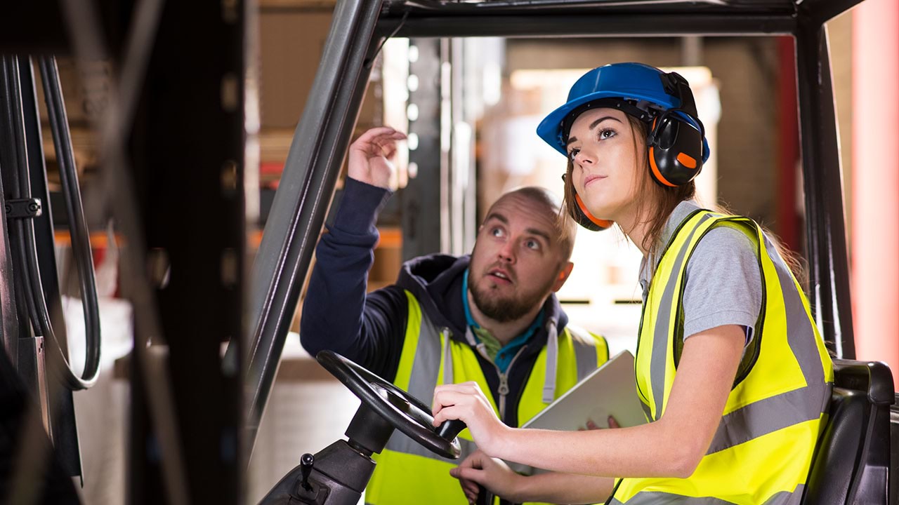 Two people working on forklift