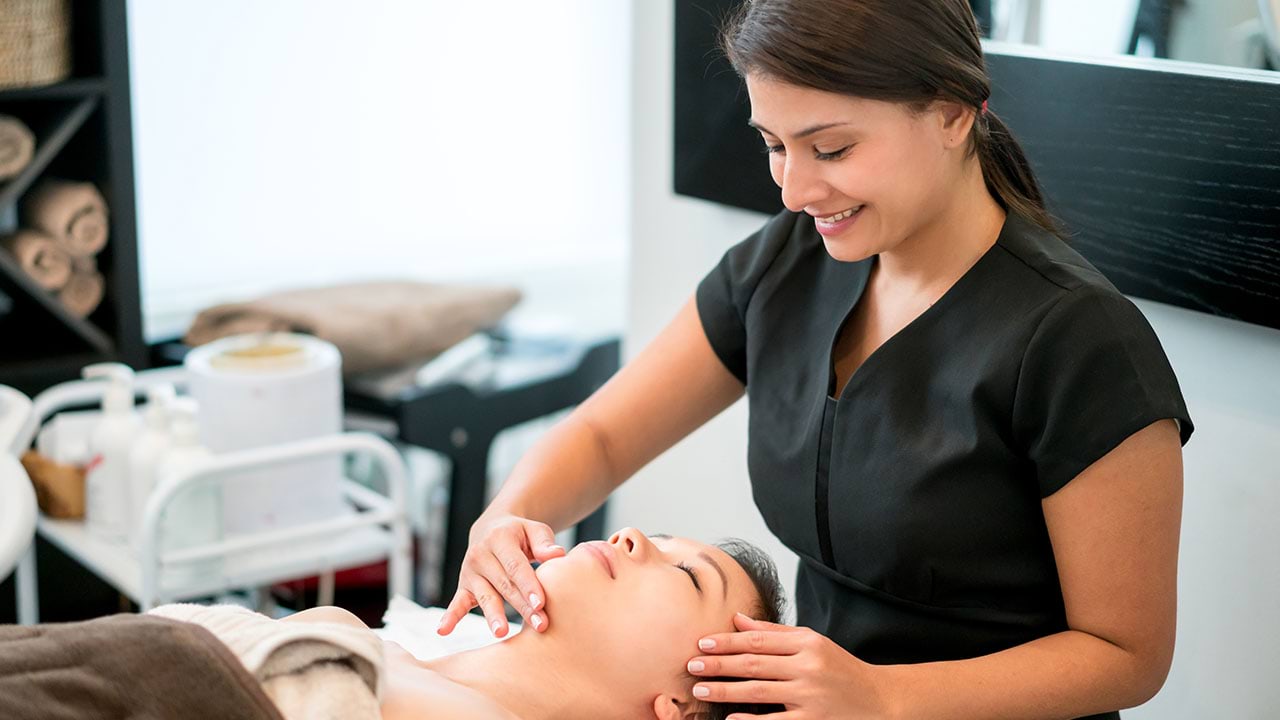 Beauty therapist touching their clients face in salon setting