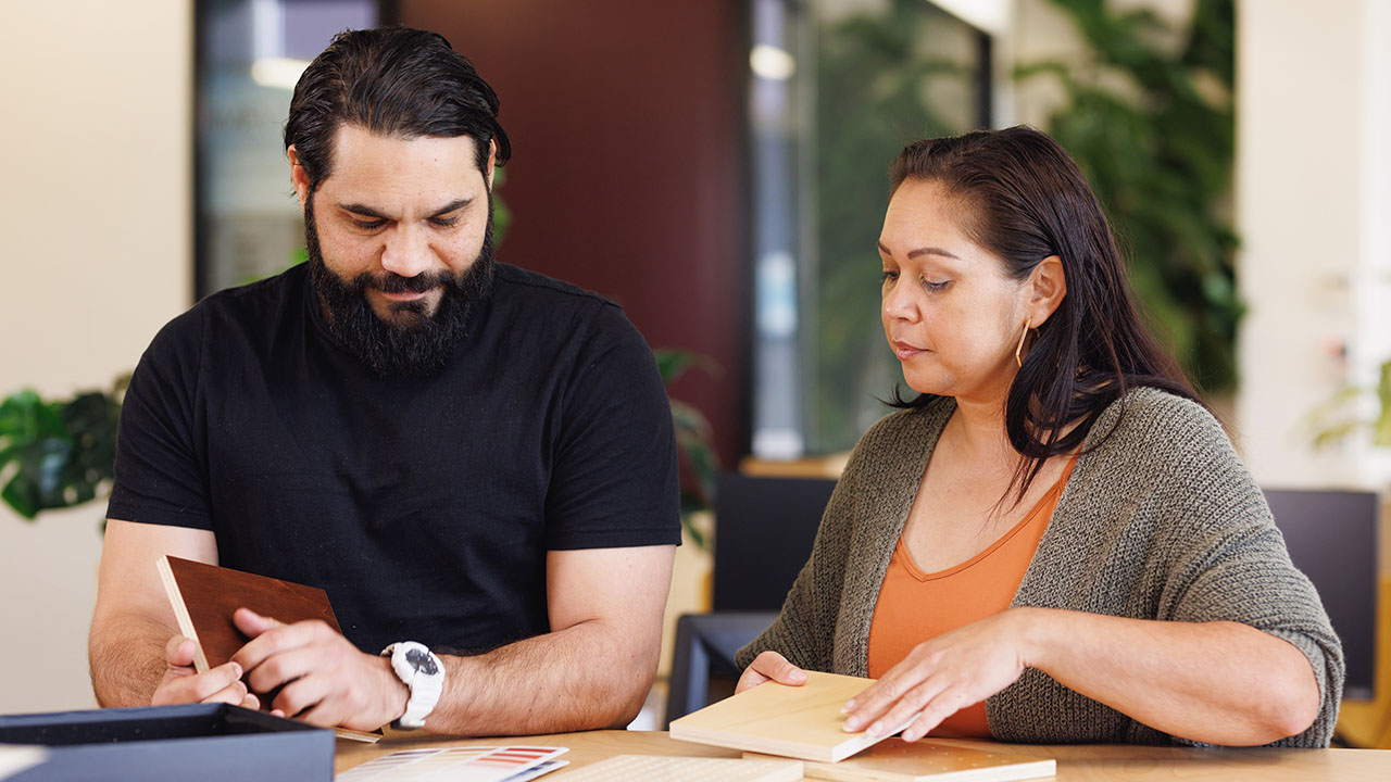 People looking at paperwork behind a counter