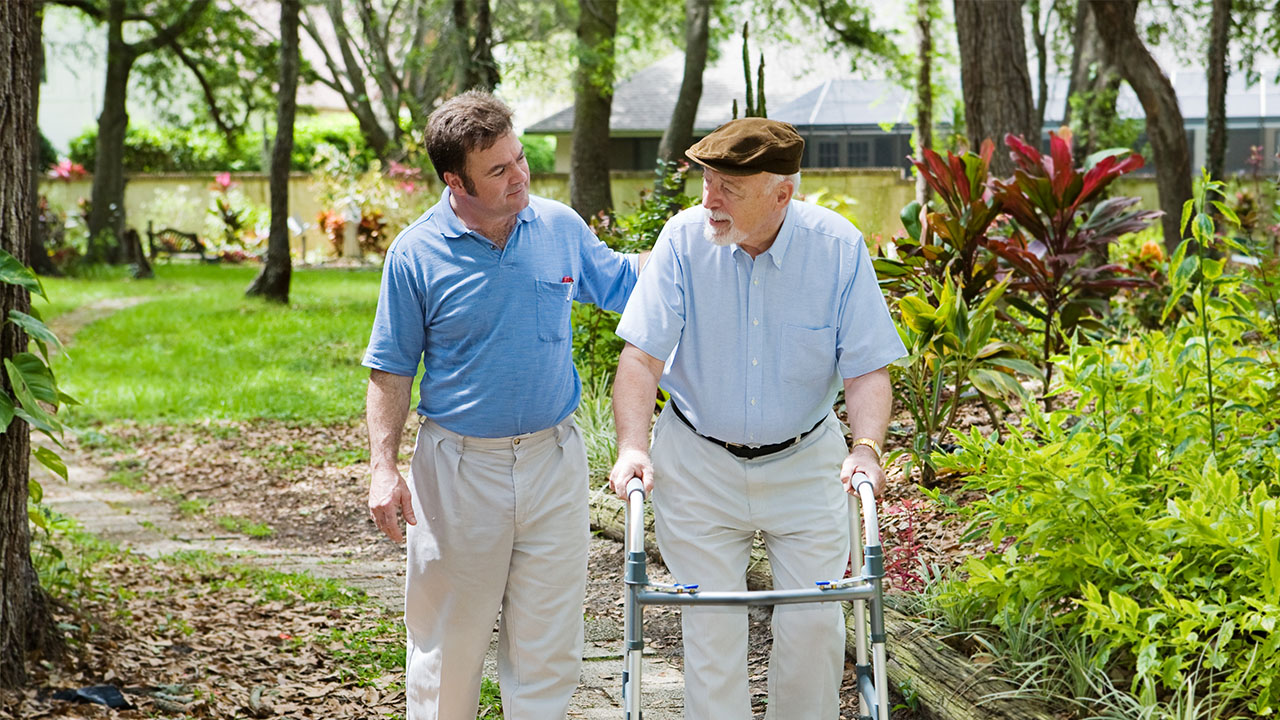 Carer assisting patient in outdoor setting